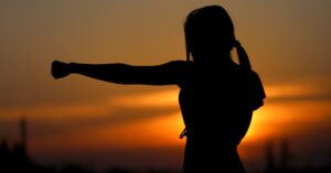 an outline of a woman punching the air