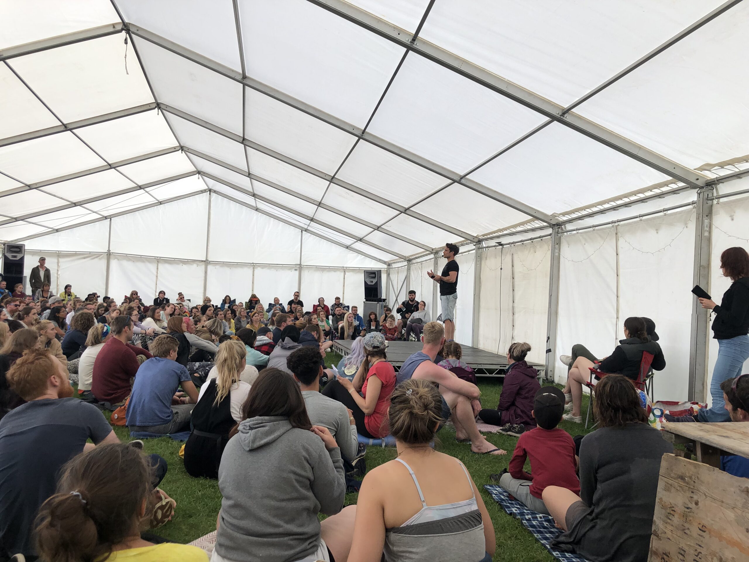 A crowds full of people listening to a speaker on stage