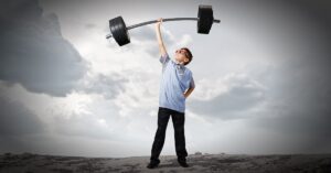 A young person holding up a huge weight