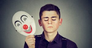 A person standing with a clown mask