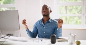 Person meditating at their desk